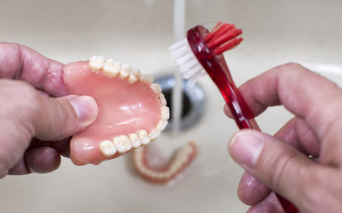 Какой пастой чистить зубные протезы