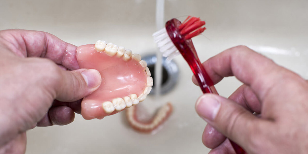 Какой пастой чистить зубные протезы